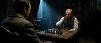 Two men playing chess in dimly lit library with dramatic lighting streaming through window creating atmospheric intellectual game scene.