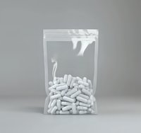 White pharmaceutical capsules in transparent zip lock plastic bag on neutral background, medical and healthcare concept for drug packaging presentation.
