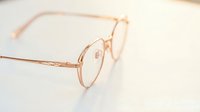 Vintage round metal eyeglasses with rose gold frames on neutral background, suitable for fashion, retail, eyewear marketing and lifestyle content.