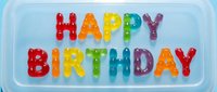 Happy birthday greeting with colorful bubble letters on light blue background, isolated design element suitable for greeting cards, invitations, party decorations, and digital celebrations.