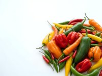 Fresh assorted chili peppers and bell peppers isolated on white background, ready for culinary design, recipe content, and food packaging projects.