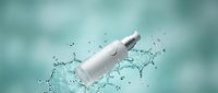 White cosmetic bottle with pump dispenser splashing in clear water with dynamic droplets against soft turquoise background for skincare advertising.