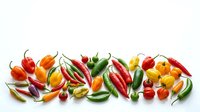 Assorted hot chili peppers in red, yellow, orange and green varieties arranged on white background for culinary and cooking design projects.