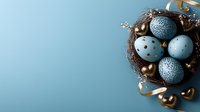 Decorative Easter nest with blue speckled eggs and golden ornaments on pastel blue background with copy space for seasonal greeting cards and designs.