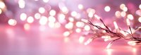 Glowing fairy lights creating magical bokeh effect on pink background, decorative branch with warm white LED string lights for festive atmosphere.