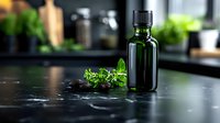 Dark green glass essential oil bottle with fresh herbs and black stones on dark surface, moody atmospheric lighting for wellness and aromatherapy concepts.