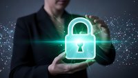 Professional businessman in dark suit holding glowing green digital padlock symbol representing cybersecurity and data protection technology solutions.