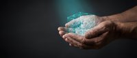 Hands holding glowing digital cube with network connections, representing technology innovation, data security, and digital transformation for business solutions.