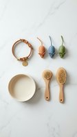 Pet care essentials with collar, toys, bowl and grooming brushes arranged on marble surface for cats and small dogs.