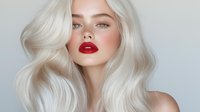 Young woman with platinum blonde wavy hair, bright red lipstick and natural glowing makeup against light background. Professional beauty portrait showcasing modern glamour style.