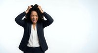 Frustrated African American businesswoman in suit pulling hair showing stress and overwhelm isolated on white background for workplace mental health concepts.