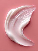 White creamy cosmetic texture smear on pink background, showing smooth moisturizer or skincare product consistency for beauty and care industry.