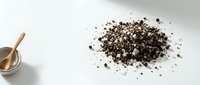Organic chia seeds scattered on white surface with wooden spoon, healthy superfood ingredient for nutrition and wellness recipes.