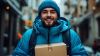 Happy delivery man in blue winter jacket holding package box smiling outdoors in urban street setting for shipping and logistics services.