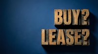 Buy or lease decision concept with wooden block letters on blue background for real estate and business choices.