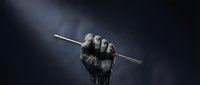 Raised fist holding a staff or rod against dark stormy sky, symbolizing resistance, protest, strength, determination, and empowerment for activism and social justice campaigns.