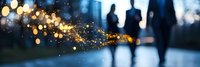Defocused romantic couple silhouettes walking in evening park with magical bokeh lights and sparkles creating dreamy atmosphere. Panoramic composition.