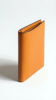 Tan leather bifold wallet with fine stitching detail, standing upright on a light surface, showcasing premium craftsmanship and minimalist style.