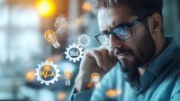 Young bearded businessman wearing glasses in deep thought with glowing innovation icons, gears and light bulbs floating around him, representing creative process.
