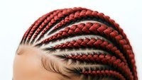 Close-up of African American woman with intricate red cornrow braids hairstyle showing detailed braiding pattern and hair texture for beauty concepts.
