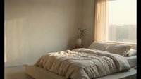 Serene minimalist bedroom with unmade bed, soft natural light from large window, neutral beige tones, and simple decor for interior design projects.