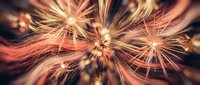 Spectacular fireworks display with golden and orange sparks radiating in brilliant bursts against dark sky for celebration and holiday events.