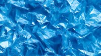 Crumpled blue plastic bags creating textured pattern background for environmental awareness campaigns and recycling concepts.