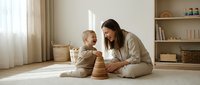 Young mother and toddler playing with wooden stacking toys on floor in bright modern living room. Family bonding time, early childhood development.