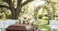 Elegant outdoor wedding ceremony setup with floral arrangements and white chairs under trees for romantic celebration events.