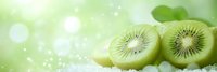 Fresh juicy kiwi fruit slices on bright green bokeh background with sparkles and copy space. Natural organic healthy food concept.
