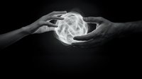 Two hands reaching toward glowing white energy sphere on black background symbolizing connection, power transfer, and spiritual healing concepts.