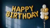 Gold foil letter balloons spelling Happy Birthday hang on a dark blue wall beside white and gold balloon bouquet, elegant party decor.