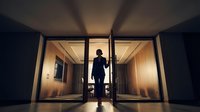 Silhouette of businessman standing in modern office building elevator with dramatic lighting and corporate architecture creating professional atmosphere.