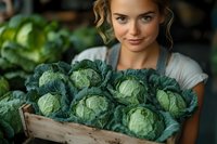 Young Caucasian woman holding wooden crate of fresh green cabbage heads at farmers market. Organic produce concept for healthy eating and local agriculture.