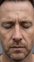 Middle-aged Caucasian male with closed eyes, facial stubble, and prominent forehead wrinkles displaying stress or fatigue. Suitable for healthcare, wellness, and emotional expression concepts.