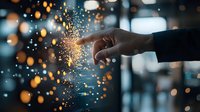 Magical finger touch creating glowing sparks and bokeh light effect against dark background, concept of innovation and digital transformation.