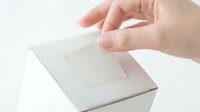 Person with light skin tone inserting ballot into white box during voting process, election concept for civic participation and democratic rights.