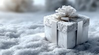 Silver gift box with white ribbon and bow sitting in fresh snow for holiday celebrations and winter festivities.