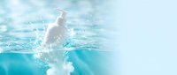 Young athletic man swimming freestyle stroke in crystal clear blue pool water with dynamic splash and bubbles creating refreshing summer sports scene.