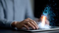 Digital startup rocket launching from laptop keyboard with glowing blue particles effect, symbolizing business growth and technological innovation in modern workspace.