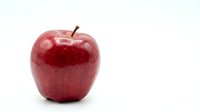 Fresh red apple with glossy skin isolated on white background for healthy eating and nutrition concepts.
