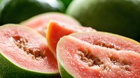 Fresh ripe guava fruit cut in half showing pink flesh and seeds, tropical exotic fruit for healthy eating and nutrition concepts.