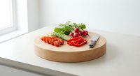Fresh vegetables on wooden cutting board with knife in bright kitchen setting ready for healthy meal preparation and cooking.