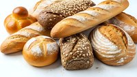 Assorted fresh baked bread loaves and rolls including baguettes, sourdough, whole grain and artisan varieties isolated on white background for bakery design.