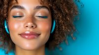 Young African American woman with curly hair and bright blue eyeshadow wearing headphones, eyes closed with serene expression, listening to music against turquoise background.