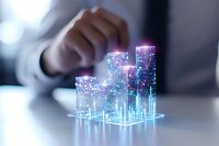 Glowing holographic financial charts with rising bars showing business growth and analytics data visualization on office desk with blurred background.