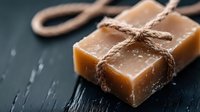 Homemade salted caramel fudge pieces tied with rustic twine on dark slate background, selective focus with soft natural lighting and textured surface.