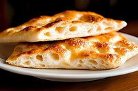 Fresh baked focaccia bread slices with golden crust and airy texture on white plate, artisan bakery product for Mediterranean cuisine and cooking.