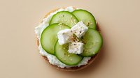 Fresh cucumber slices with creamy cheese spread on toasted bread, healthy breakfast or snack option for clean eating and wellness lifestyle.