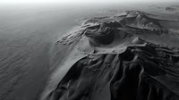 Dramatic aerial view of volcanic crater with rugged terrain and atmospheric lighting in monochrome black and white photography showcasing natural geological formations.